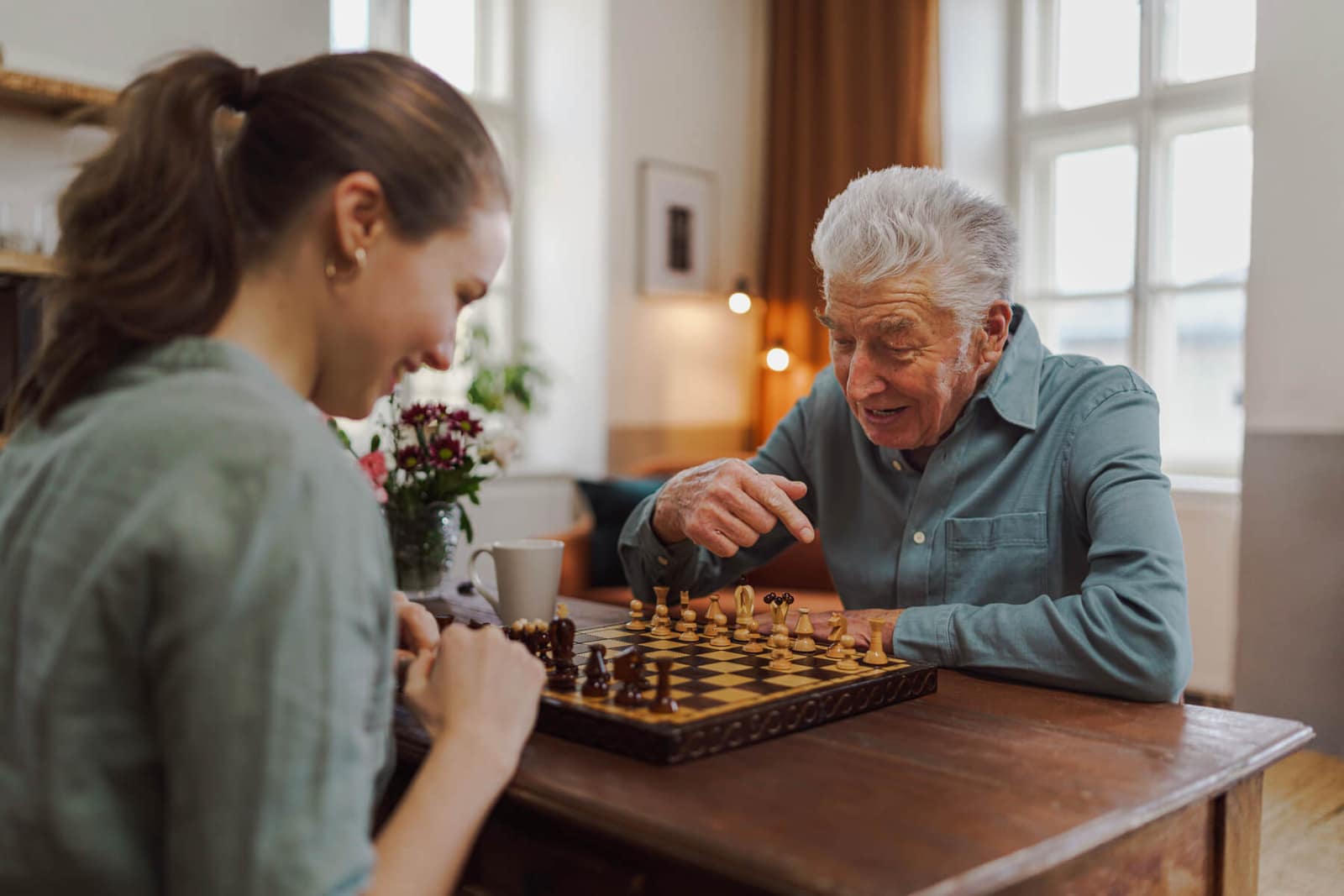 Senior man playing chess during home care