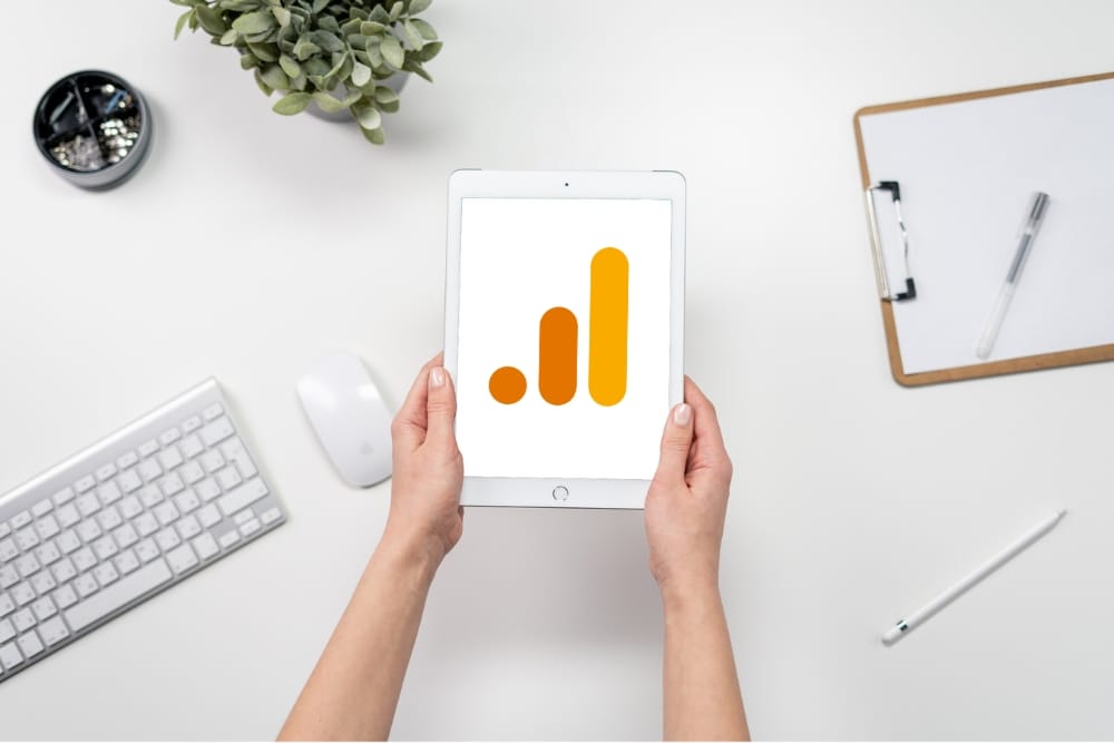Woman holding an iPad showing the Google Analytics logo